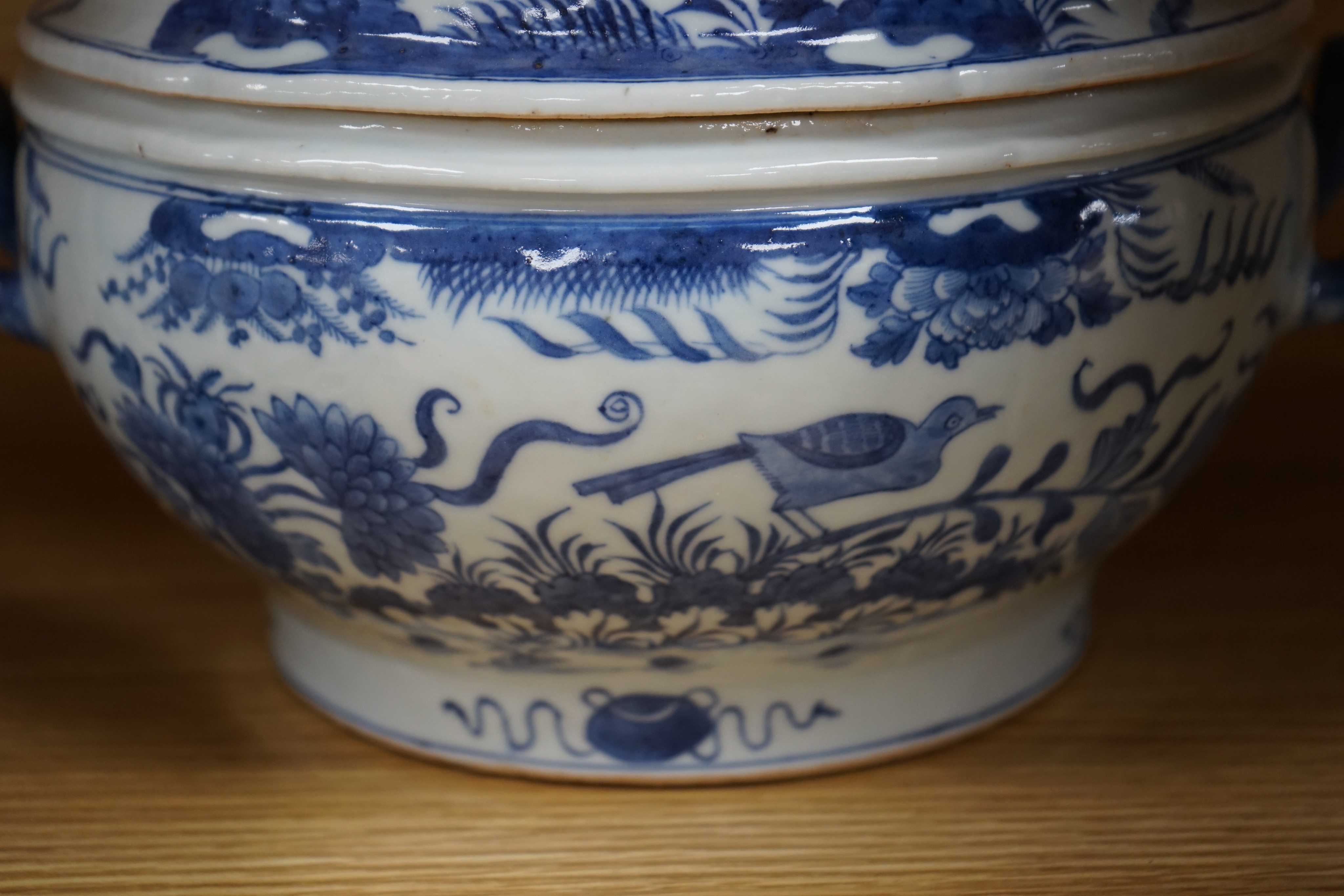 An 18th century Chinese Export blue and white octagonal tureen and cover, decorated with birds and flowers, a pair of similar sauceboats and five plates decorated with urns of flowers